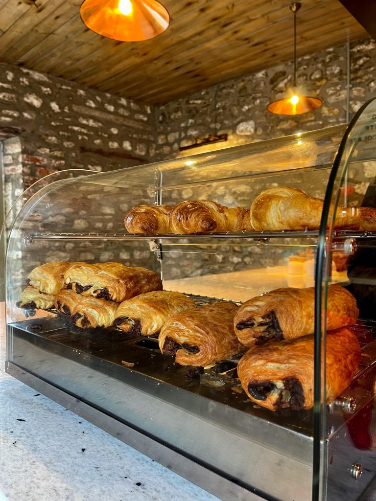 Morning coffee setup at Cat's Kitchen with a display of pastries and a coffee machine.
