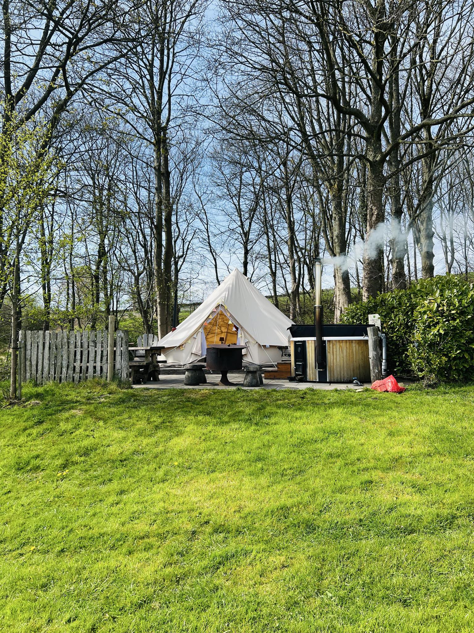 Luxury bell tent with private hot tub and firepit patio at Bolton Abbey, surrounded by woodland